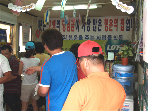 홍성 천하명당 복권방. 복권을 사려는 사람들로 가득차 있다. 